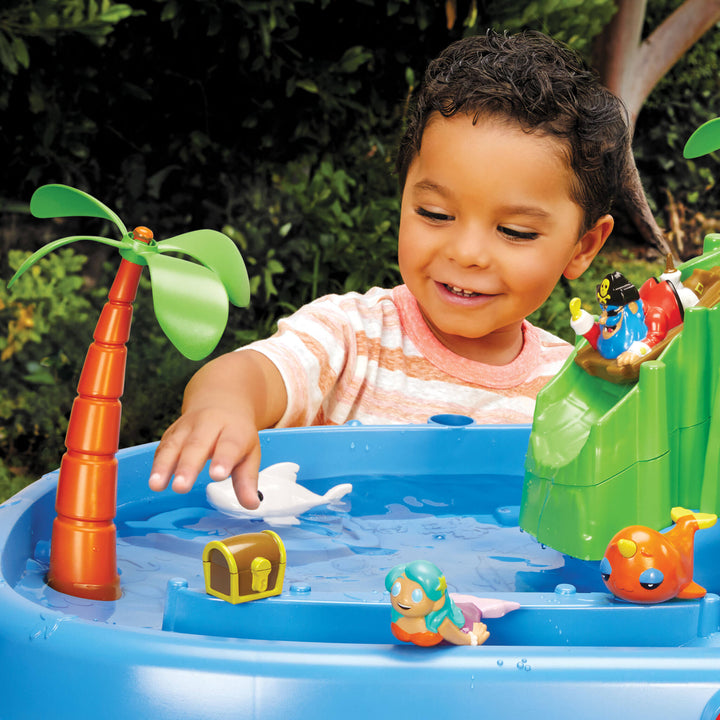 Child playing with a toy water table set outdoors