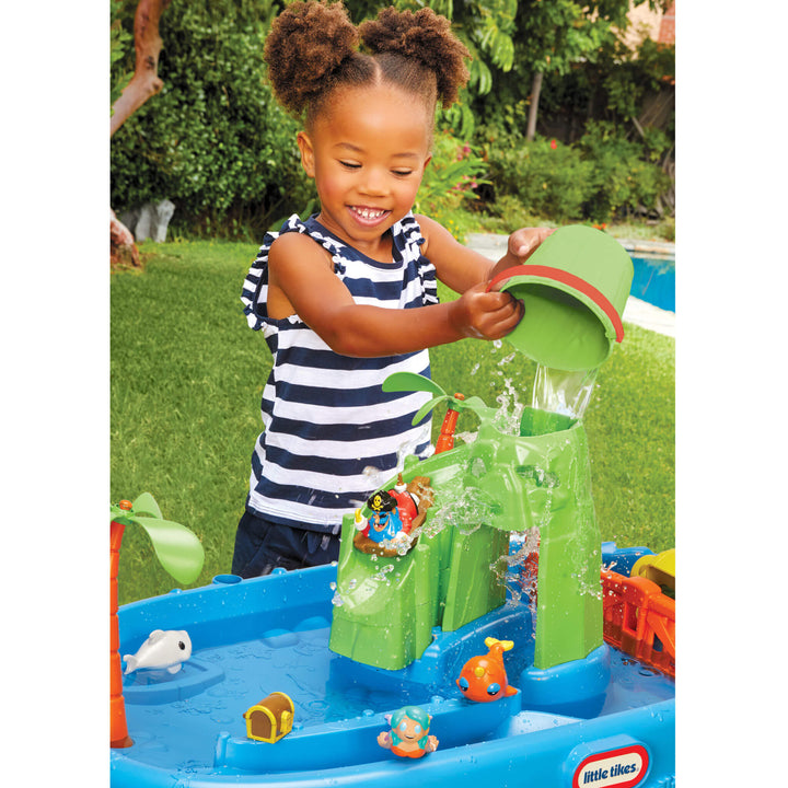 Child playing with a water play set in an outdoor setting