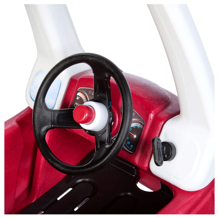 Black steering wheel with red horn, black key on the right, white pillar.