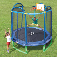 Child playing on a trampoline with basketball hoop and net in an outdoor setting.