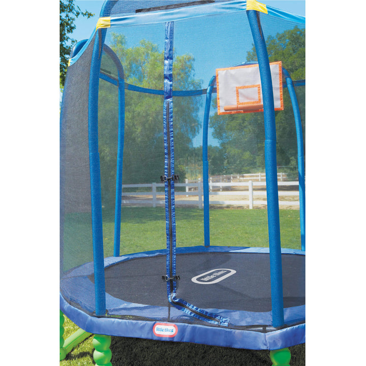Blue trampoline with safety net and basketball hoop in a backyard setting