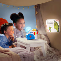 Two children sitting in a cozy room with a night light and a book.