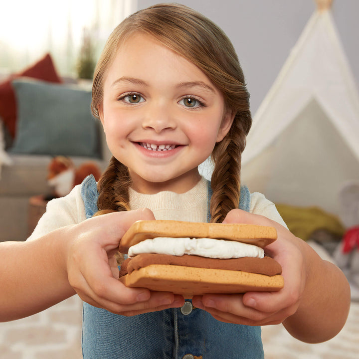Child holding a s'mores cookie stack 