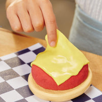 Play hamburger with yellow cheese on a checkered tablecloth