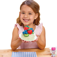 Young girl holding the cake with fruits on a white background