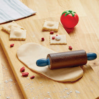 Wooden rolling pin on a wooden surface with dough