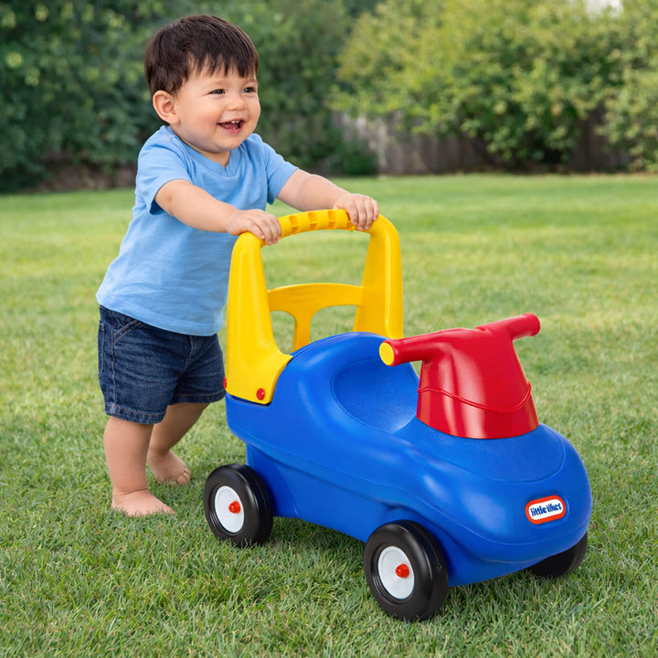 Child playing with a colorful toy car on grass