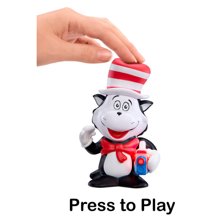 Toy figure of a cat in the hat with a hand pressing a button labeled 'Press to Play'.