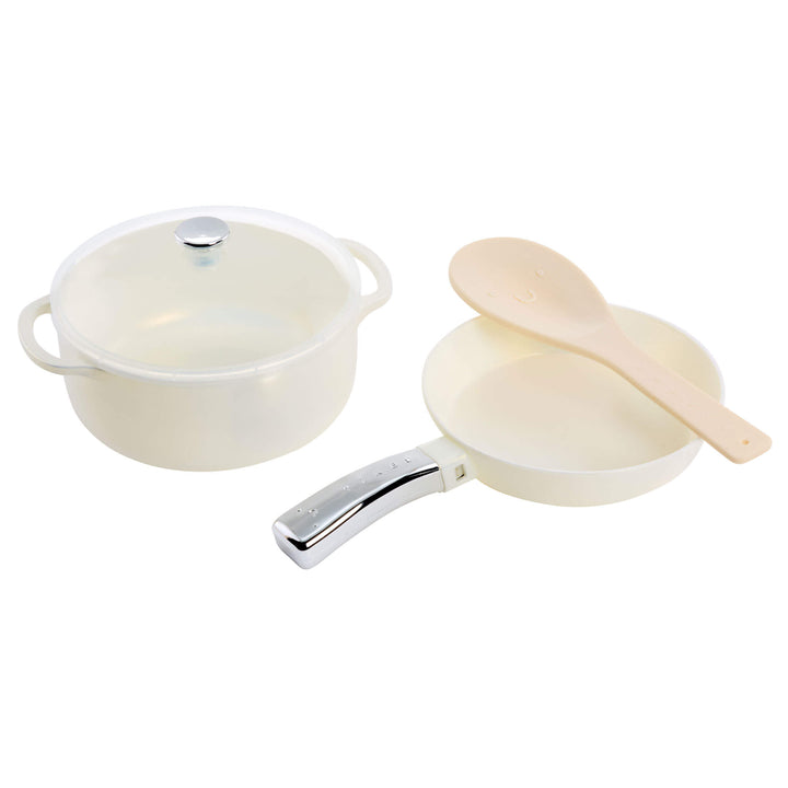 Set of white toy cookware with a lid, a pot, a pan, and a ladle on a white background