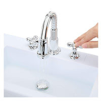 Hand on silver knobs with water coming out of faucet shown on a white background