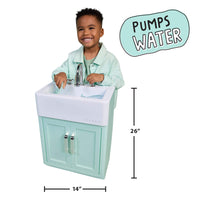 A child stands behind a small mint green and white vanity sink with a faucet, shown on a white background with dimension labels reading 14 inches wide, 26 inches tall, and a badge that says 'PUMPS WATER'.