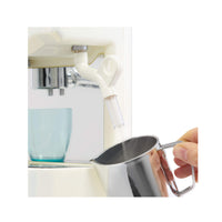 Hand holding a silver milk frother by an Espresso machine on a white background.