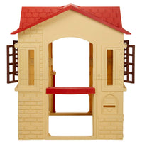 A playhouse shaped like a small house with a beige brick-textured body, red tiled roof, and brown shutters, shown on a plain white background.