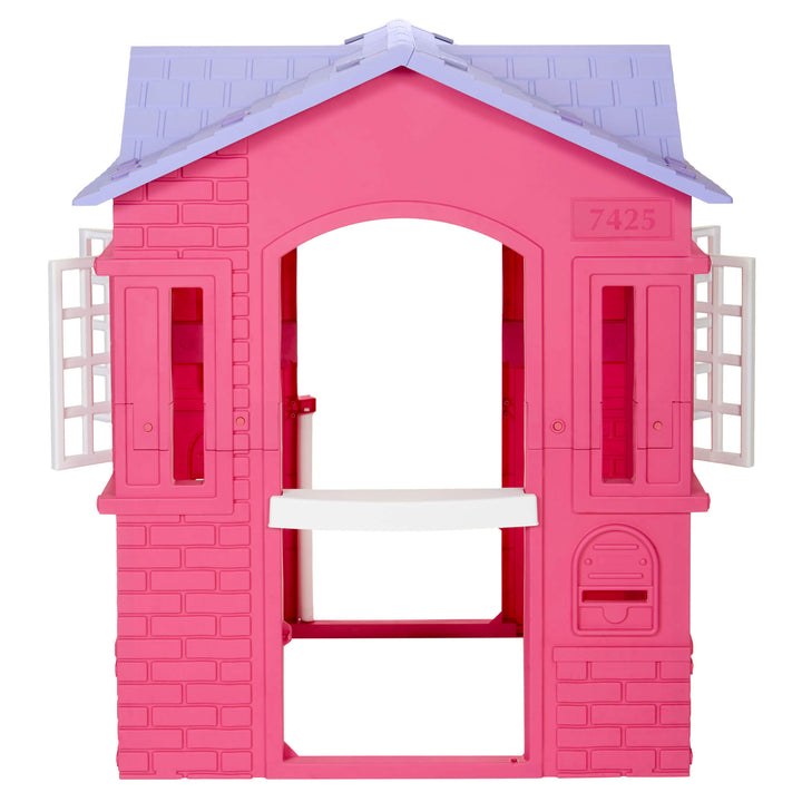 A pink plastic house playset with a light purple roof, white shutters, and a white bench, shown on a solid white background.