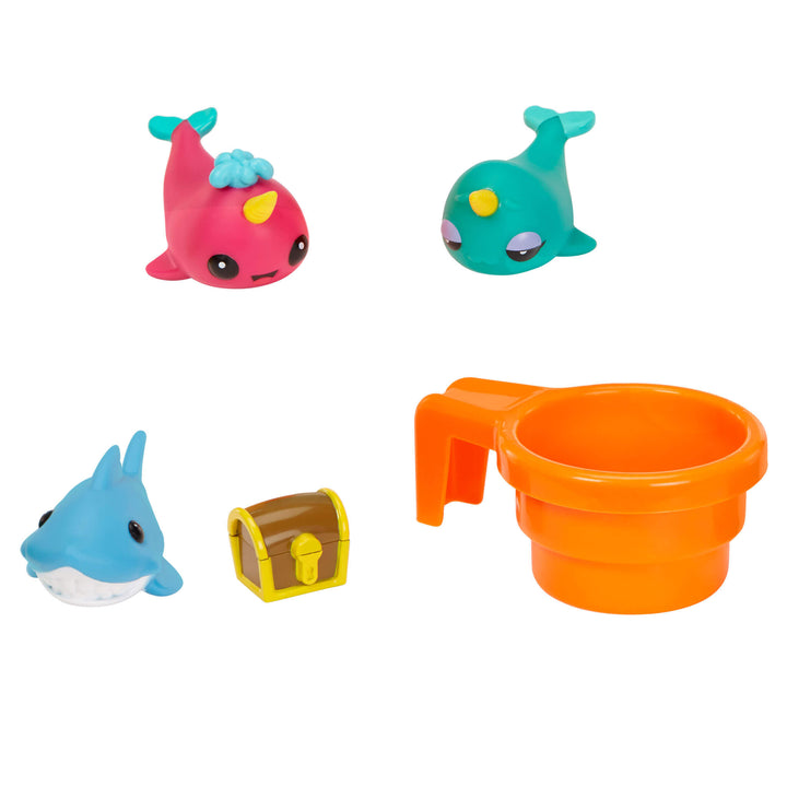 Set of colorful toy dolphins, a whale with a treasure chest and orange cup on a white background