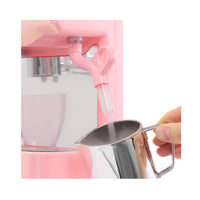 Pink Espresso machine with a silver cup being used to add ingredients.