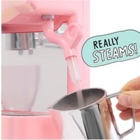 A pink espresso machine  dispensing steam into a pitcher held by a hand, with a mint-green speech bubble reading 'REALLY STEAMS!' on a white background.