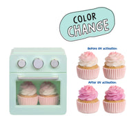 A toy miniature oven toy with two pink-and-white frosted cupcakes inside, shown on a white background with a 'COLOR CHANGE' graphic and before/after cupcake examples demonstrating a reversible color-changing feature.