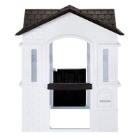 A white plastic playhouse with a black tiled roof featuring an open back with a mail slot isolated on a white background.