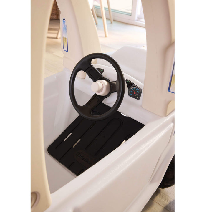 Black steering wheel with white horn button and black floorboard