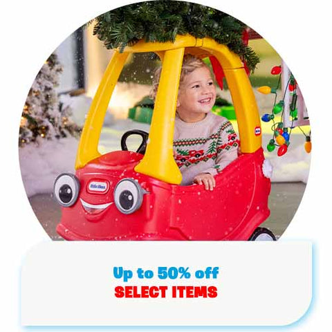 Child in a red and yellow toy car with Christmas decorations in the background