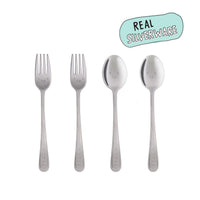Four-piece stainless steel cutlery set with cute engraved faces on the handles, shown on a white background with a light blue 'REAL SILVERWARE' badge in the top right.