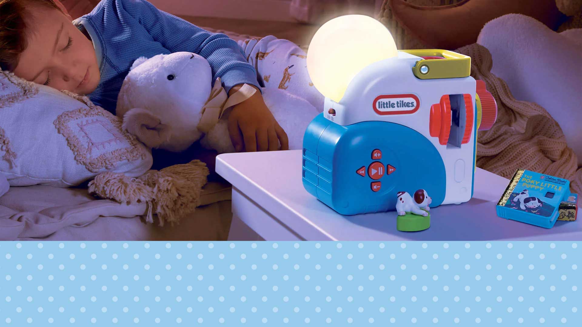 Child sleeping with a toy night light and teddy bear on a bed
