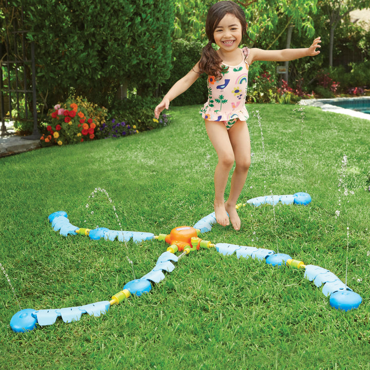 Girl playing in the sprinkler
